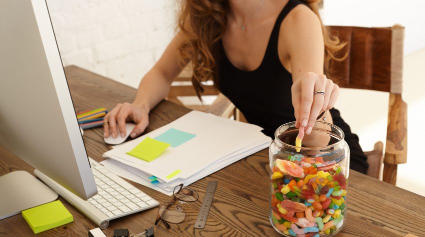 Cropped,Image,Of,Young,Stressed,Woman,Eating,Sweets,At,Workplace